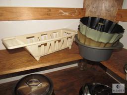 Contents of kitchen cabinet includes pots pans and cake pans