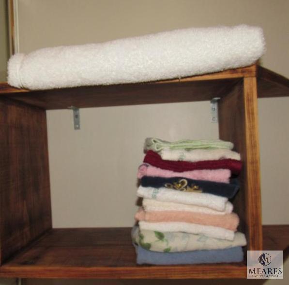 Contents of bathroom includes pictures, Linens, waste basket, laundry basket