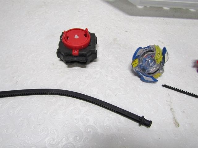Beyblades And A Battle Stadium For Them Plus Accessories Shown