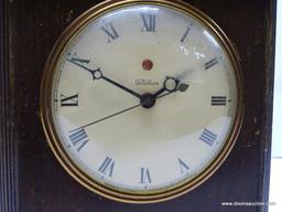 TELECHRON ELECTRIC SHELF CLOCK. MAHOGANY CASE WITH SCALLOP CUT SKIRT AT THE FRONT, BROKEN ARCH