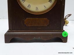 TELECHRON ELECTRIC SHELF CLOCK. MAHOGANY CASE WITH SCALLOP CUT SKIRT AT THE FRONT, BROKEN ARCH