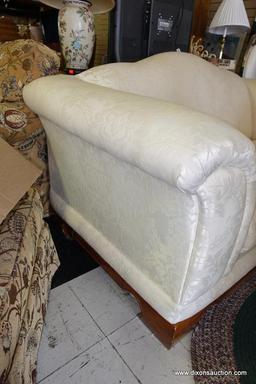 (R1) CREAM-COLORED LOVESEAT; 2 CUSHION SEAT WITH TIGHT BACK, SEMI-ROLLED ARMS, AND BRACKET