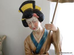 (BED) PORCELAIN GEISHA GIRL STATUE; HOLDING PARASOL, IN MUTED SHADES OF TAN, BLUE, RED, AND YELLOW,