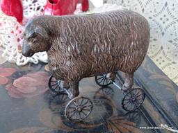 VINTAGE SHEEP PULL-TOY; SITS ON A PAIR OF ROLLING WHEELED AXLES, METALLIC BLACK AND BRONZED COLOR.