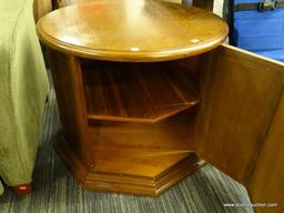 DRUM-SHAPED END TABLE/CABINET; ROUND TOP SURFACE WITH 8 PANELED SIDES BENEATH, 2 OF WHICH FORM A