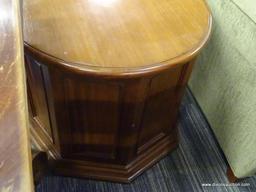 DRUM-SHAPED END TABLE/CABINET; ROUND TOP SURFACE WITH 8 PANELED SIDES BENEATH, 2 OF WHICH FORM A