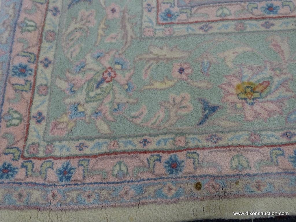 HAND KNOTTED ORIENTAL AREA RUG WITH SOME STAINING. IS IN PASTEL GREENS, YELLOWS, AND PINKS. MEASURES