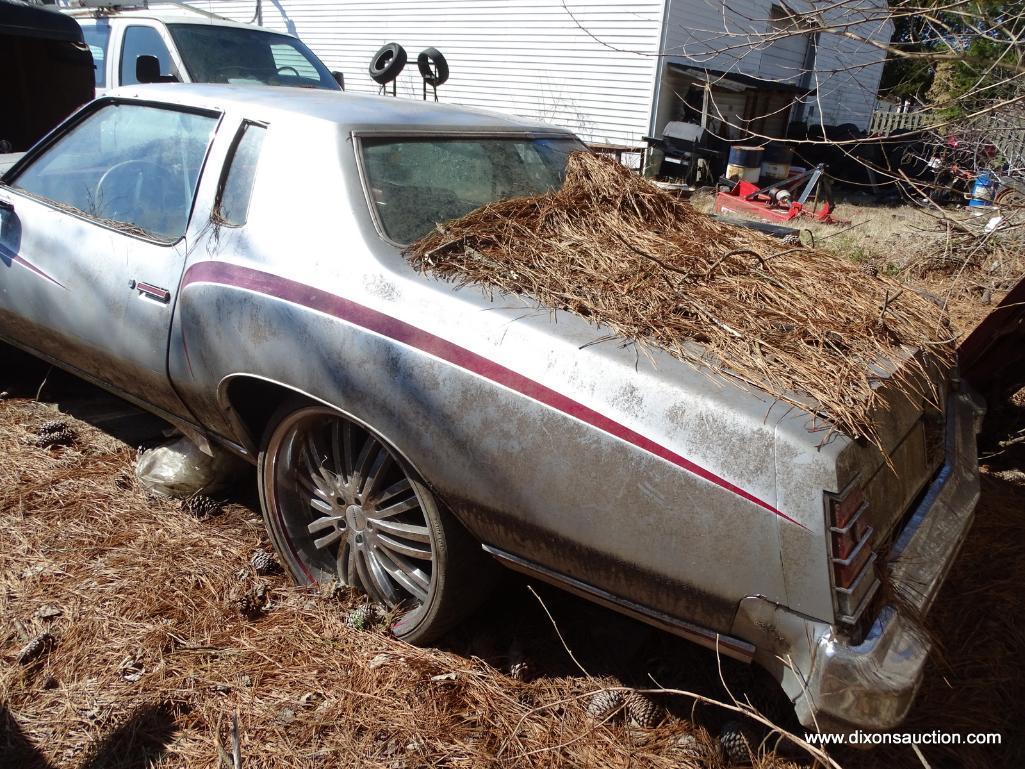 1977 SILVER MONTE CARLO; VIN 1H57U7B587408. SILVER WITH RED STRIPES. THIS CAR WAS ABANDONED AT A