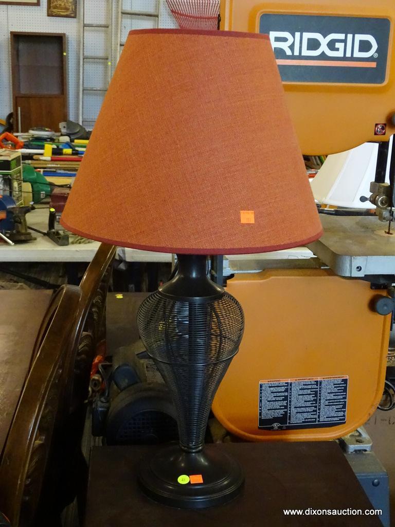 TABLE LAMP; BLACK IN COLOR WITH A RED BELL SHAPED SHADE AND WIRE URN SHAPED BODY. MEASURES 29 IN