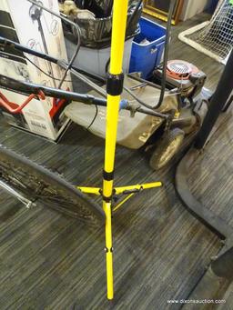 WORK LIGHT; YELLOW AND BLACK IN COLOR WITH TWO AIMABLE LIGHTS ON AN EXTENDABLE STAND. MAX HEIGHT 63