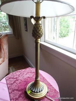 (FAM) BRASS TONE TABLE LAMP; WHITE BELL SHAPED SHADE SITTING ON A TALL CANDLESTICK STYLE BODY WITH