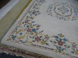 hand knotted area rug; cream colored floral rug with pink, yellow and blue flowers. has fringe