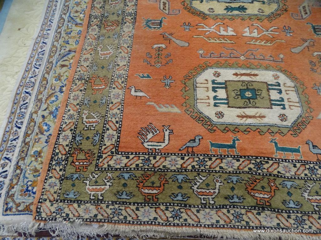 HAND KNOTTED AREA RUG; RED-ORANGE RUG WITH CREAM AND TAN BORDER WITH ANIMALS ON IT. HAS FRINGE