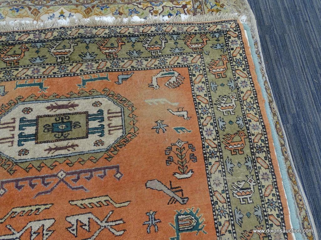 HAND KNOTTED AREA RUG; RED-ORANGE RUG WITH CREAM AND TAN BORDER WITH ANIMALS ON IT. HAS FRINGE