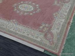 HAND KNOTTED RUG; PINK AND CREAM HAND KNOTTED RUG WITH BLUE, GREEN, AND ROSE COLORED FLOWERS. HAS