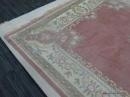 HAND KNOTTED RUG; PINK AND CREAM HAND KNOTTED RUG WITH BLUE, GREEN, AND ROSE COLORED FLOWERS. HAS