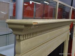 VINTAGE FIREPLACE MANTELS; CREAM/PALE YELLOW COLORED WOODEN MANTEL WITH DENTAL MOLDING AROUND THE