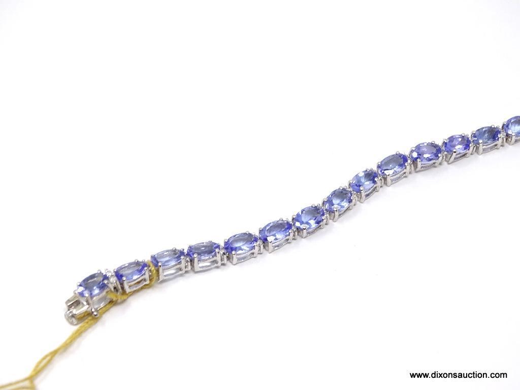 TANZANITE AND DIAMOND 7 INCH BRACELET; 14KT WHITE GOLD SETTING WITH 26 OVAL MIXED CUT NATURAL