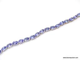 TANZANITE AND DIAMOND 7 INCH BRACELET; 14KT WHITE GOLD SETTING WITH 26 OVAL MIXED CUT NATURAL