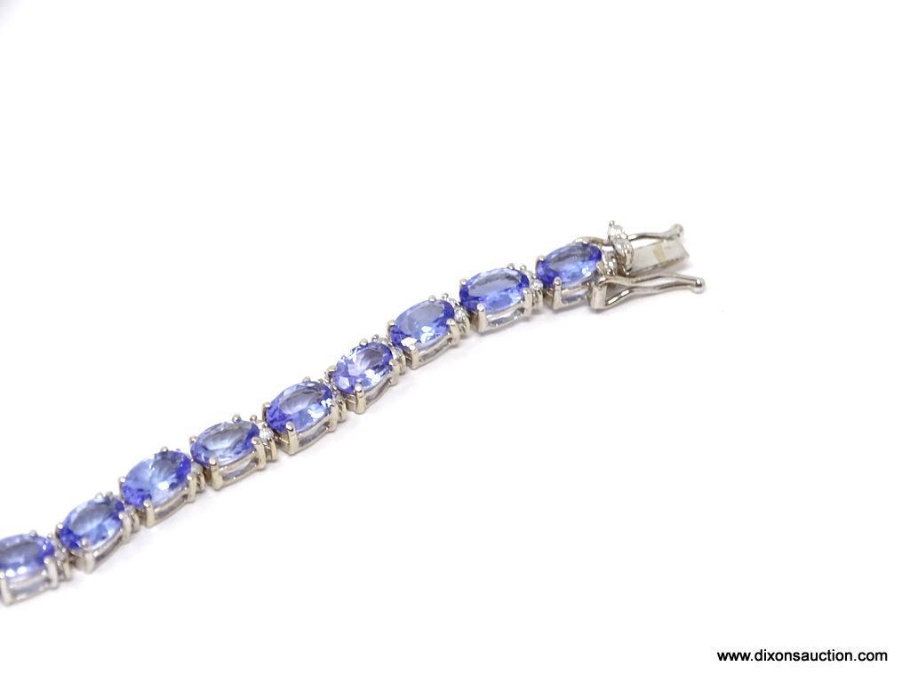 TANZANITE AND DIAMOND 7 INCH BRACELET; 14KT WHITE GOLD SETTING WITH 26 OVAL MIXED CUT NATURAL