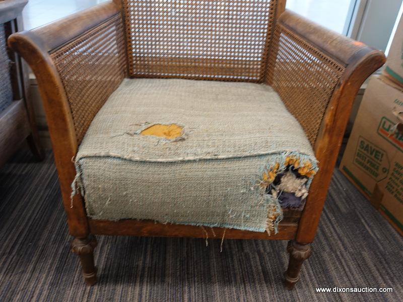 (DOOR) WICKER ARMCHAIR; WOODEN ARMCHAIR WITH A WICKER LACED BACK AND SIDES. HAS A FADED BLUE FABRIC,