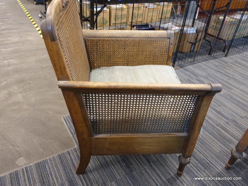 (DOOR) WICKER ARMCHAIR; WOODEN ARMCHAIR WITH A WICKER LACED BACK AND SIDES. HAS A FADED BLUE FABRIC,