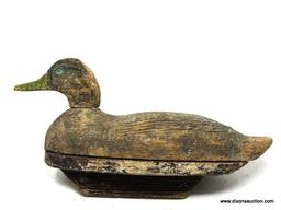 HAND CARVED BLACK DUCK DECOY. FACTORY DECOY. ATTACHED BOTTOM. GLASS EYES MISSING. EXCESSIVE PAINT.