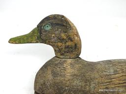 HAND CARVED BLACK DUCK DECOY. FACTORY DECOY. ATTACHED BOTTOM. GLASS EYES MISSING. EXCESSIVE PAINT.