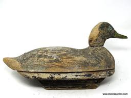 HAND CARVED BLACK DUCK DECOY. FACTORY DECOY. ATTACHED BOTTOM. GLASS EYES MISSING. EXCESSIVE PAINT.