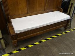 (R2) WOODEN CHURCH PEW; HAS REEDED DETAILING, ORNATE SCROLLING AT THE TOP, AND A WHITE BENCH