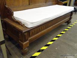 (R2) WOODEN CHURCH PEW; HAS REEDED DETAILING, ORNATE SCROLLING AT THE TOP, AND A WHITE BENCH