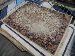 FLORAL AREA RUG; HAS A CREAM, ORANGE, NAVY, AND LIGHT BLUE COLORED GEOMETRIC FLORAL PATTERN. HAS