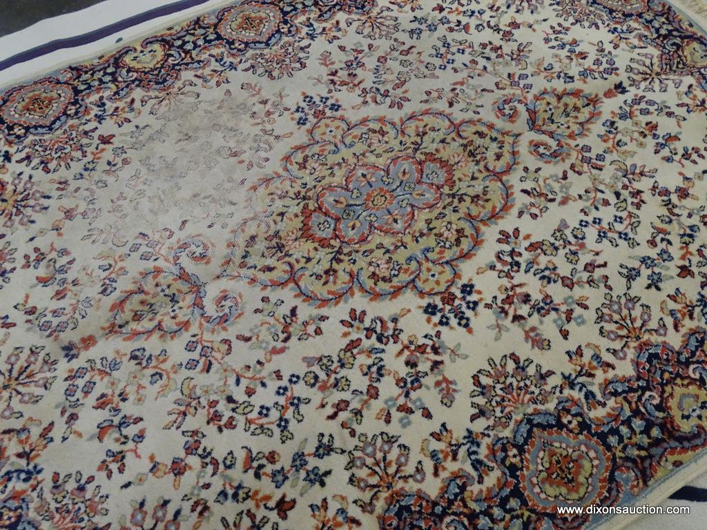 FLORAL AREA RUG; HAS A CREAM, ORANGE, NAVY, AND LIGHT BLUE COLORED GEOMETRIC FLORAL PATTERN. HAS