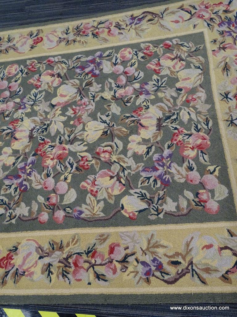 FLORAL AREA RUG; HAND WOVEN AREA RUG WITH A GREEN AND YELLOW COLOR BASE AND A PURPLE AND PINK FLOWER