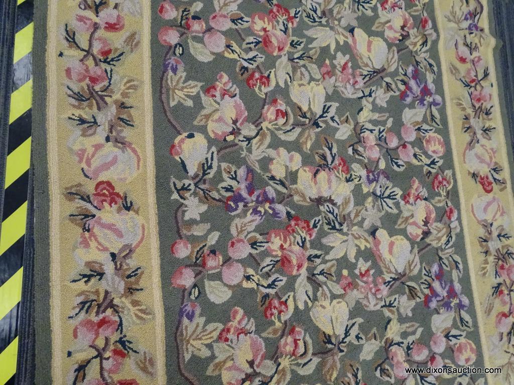 FLORAL AREA RUG; HAND WOVEN AREA RUG WITH A GREEN AND YELLOW COLOR BASE AND A PURPLE AND PINK FLOWER