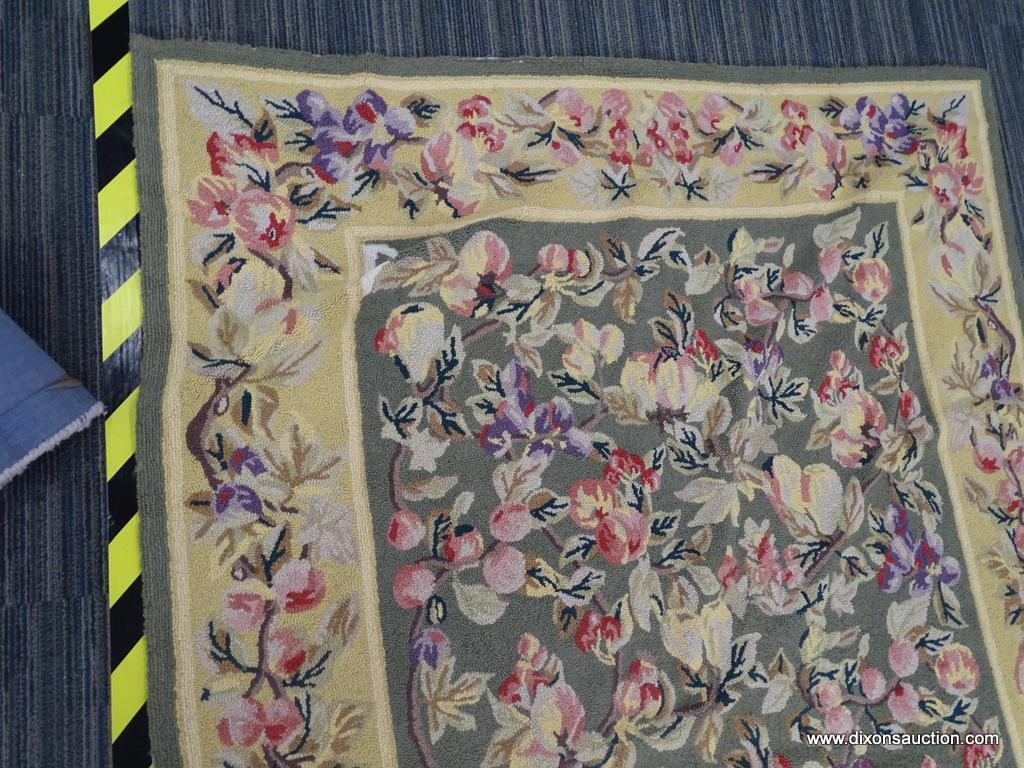 FLORAL AREA RUG; HAND WOVEN AREA RUG WITH A GREEN AND YELLOW COLOR BASE AND A PURPLE AND PINK FLOWER