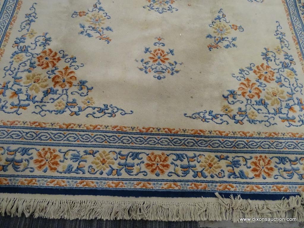 KARASTAN AREA RUG; CHINESE MEDALLION #718 AREA RUG WITH A BEIGE, ORANGE, AND BLUE COLOR. HAS FRINGES