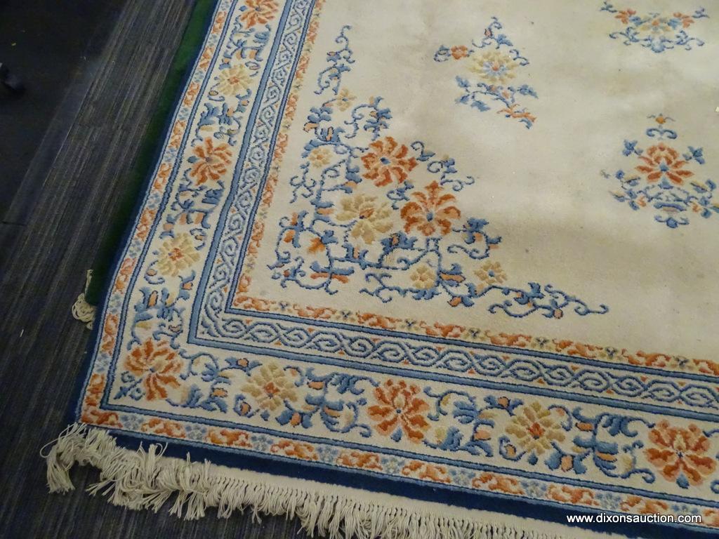 KARASTAN AREA RUG; CHINESE MEDALLION #718 AREA RUG WITH A BEIGE, ORANGE, AND BLUE COLOR. HAS FRINGES