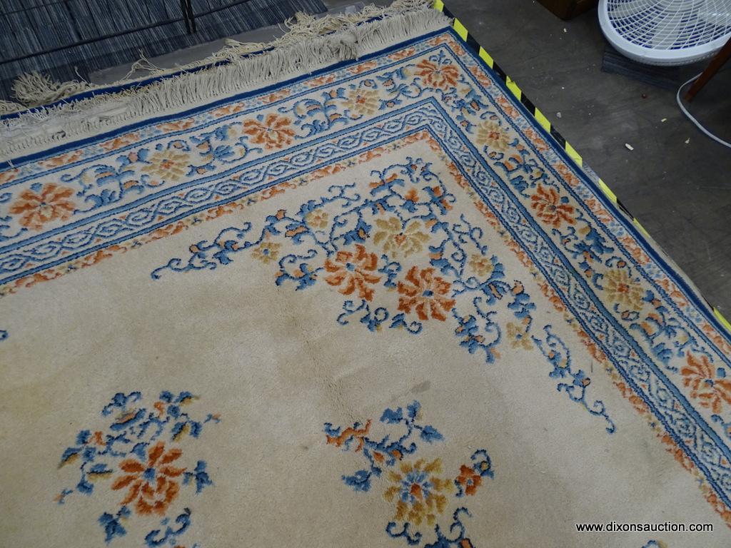 KARASTAN AREA RUG; CHINESE MEDALLION #718 AREA RUG WITH A BEIGE, ORANGE, AND BLUE COLOR. HAS FRINGES