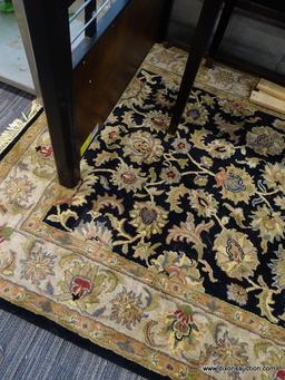 (WINDOW) RUGS USA WOOL PILE RUG; HAND TUFTED, BLACK AND BEIGE RUG WITH A FLORAL PATTERN. HAS FRINGES