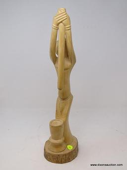 (RFRT) HAND CARVED WOODEN, AFRICAN FIGURINE OF A MAN HOLDING A POLE HIGH IN THE AIR ABOVE A BOWL,