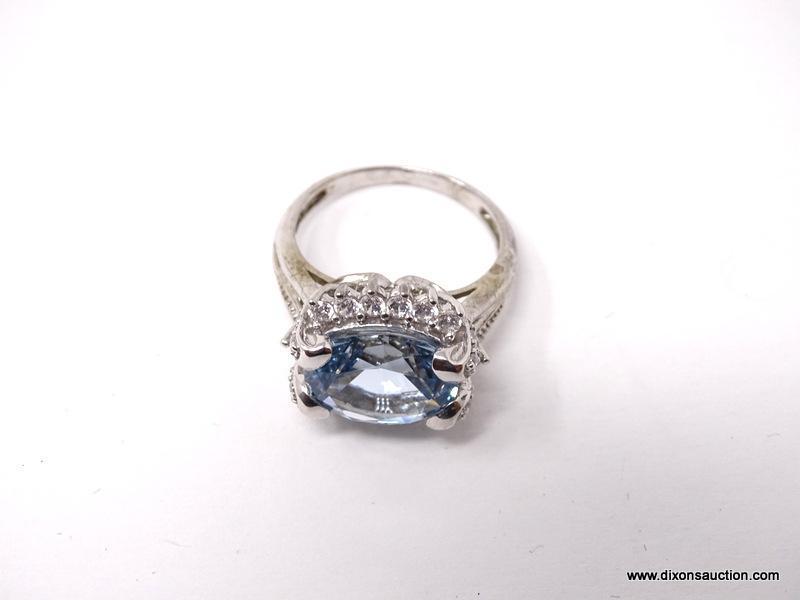 .925 STERLING SILVER RING WITH LARGE CENTER AQUAMARINE SURROUNDED BY SMALL CZ GEMSTONES. MADE BY