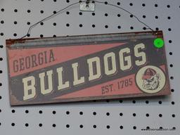 GEORGIA BULLDOGS ADVERTISING SIGN; IS RED AND BLACK IN COLOR. MEASURES 12 IN X 5.5 IN