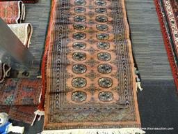 PAKISTAN BOKHARA RUG. MEASURES 2'8" X 9". SIGNED.