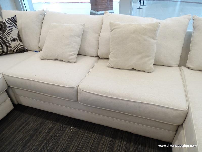 MODERN SECTIONAL SOFA WITH CREAM COLORED UPHOLSTERY AND MAHOGANY LEGS. MEASURES 142 IN X 108 IN X 36