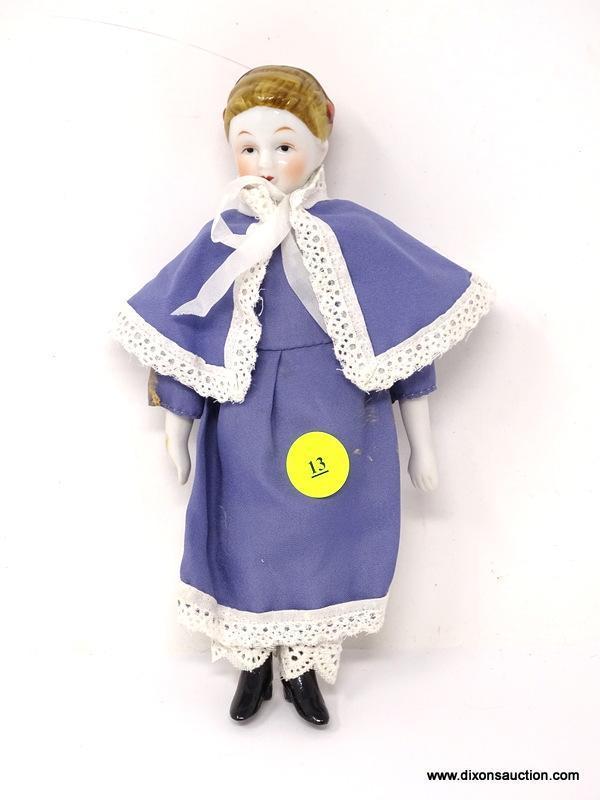 ANTIQUE PORCELAIN DOLL WITH A BLUE AND WHITE LACE DRESS. MEASURES APPROXIMATELY 8 IN TALL. ITEM IS