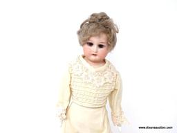 VINTAGE PORCELAIN DOLL IN AN OFF-WHITE DRESS WITH LACE ACCENTS. HAS STAND AND MEASURES 12.25 IN