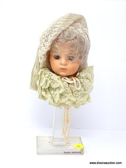 LOUIS NICHOLE PORCELAIN VICTORIAN DOLL HEAD MOUNTED ON LUCITE BASE. MEASURES 10.5 IN TALL. ITEM IS