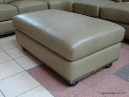 BRAND NEW TOP GRAIN LEATHER TAUPE OTTOMAN BY ABBYSON. HAS BRASS STUDDED ACCENTS ALONG THE EDGE AND