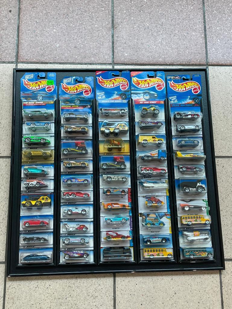 (LOCATED CENTER AISLE) HOT WHEELS CARS IN ORIGINAL PACKAGES IN BLACK DISPLAY RACK. MOSTLY 1990S